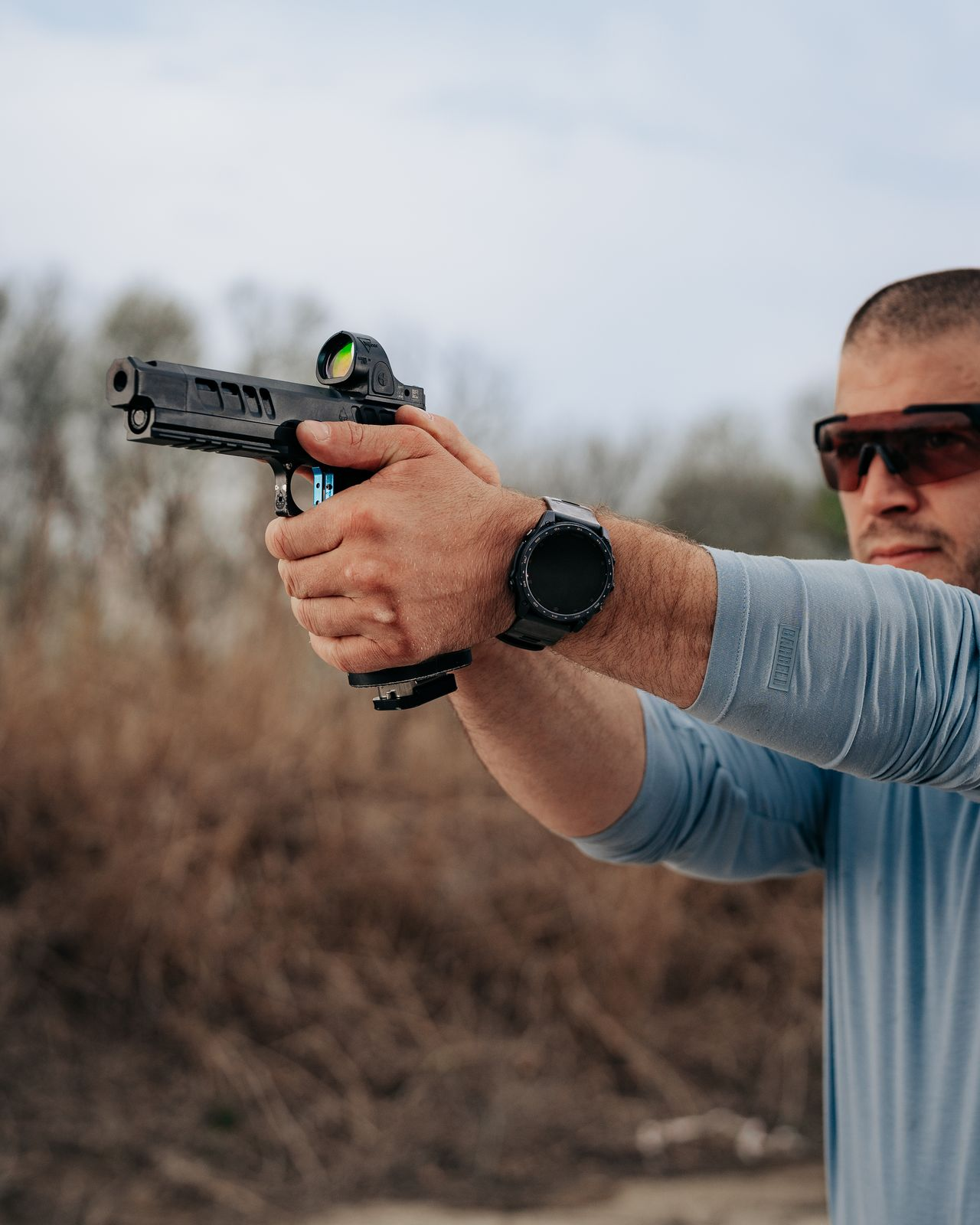 Athlete aiming pistol with Garmin Tactix 9 Pro on wrist